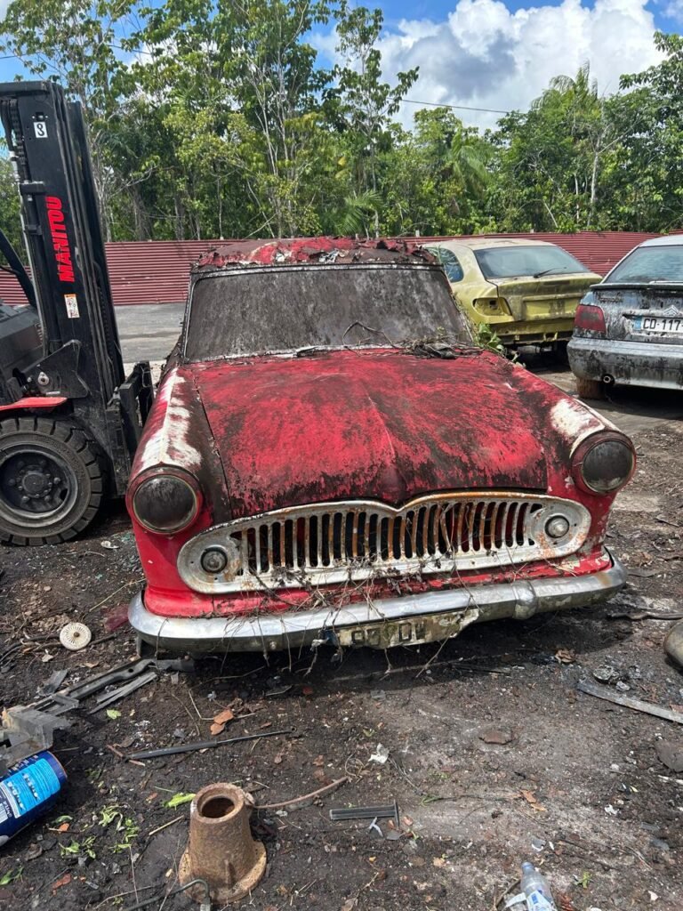 Vieille voiture rouge rouillée dans une casse.