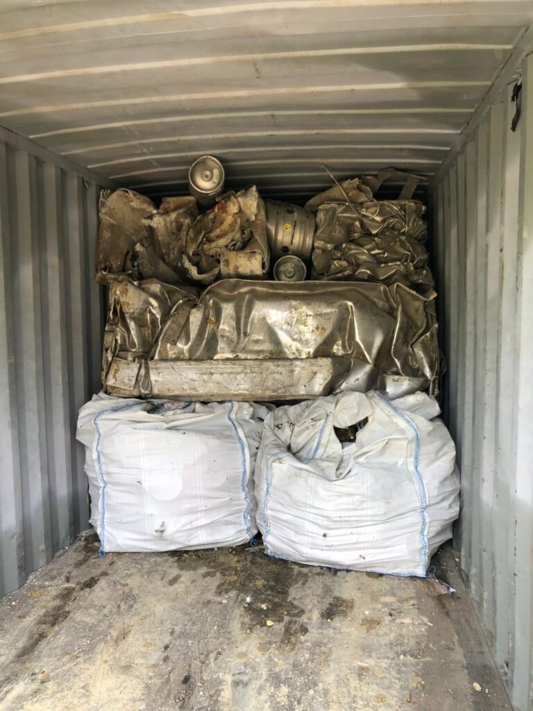 Récipients métalliques et sacs stockés dans un conteneur.